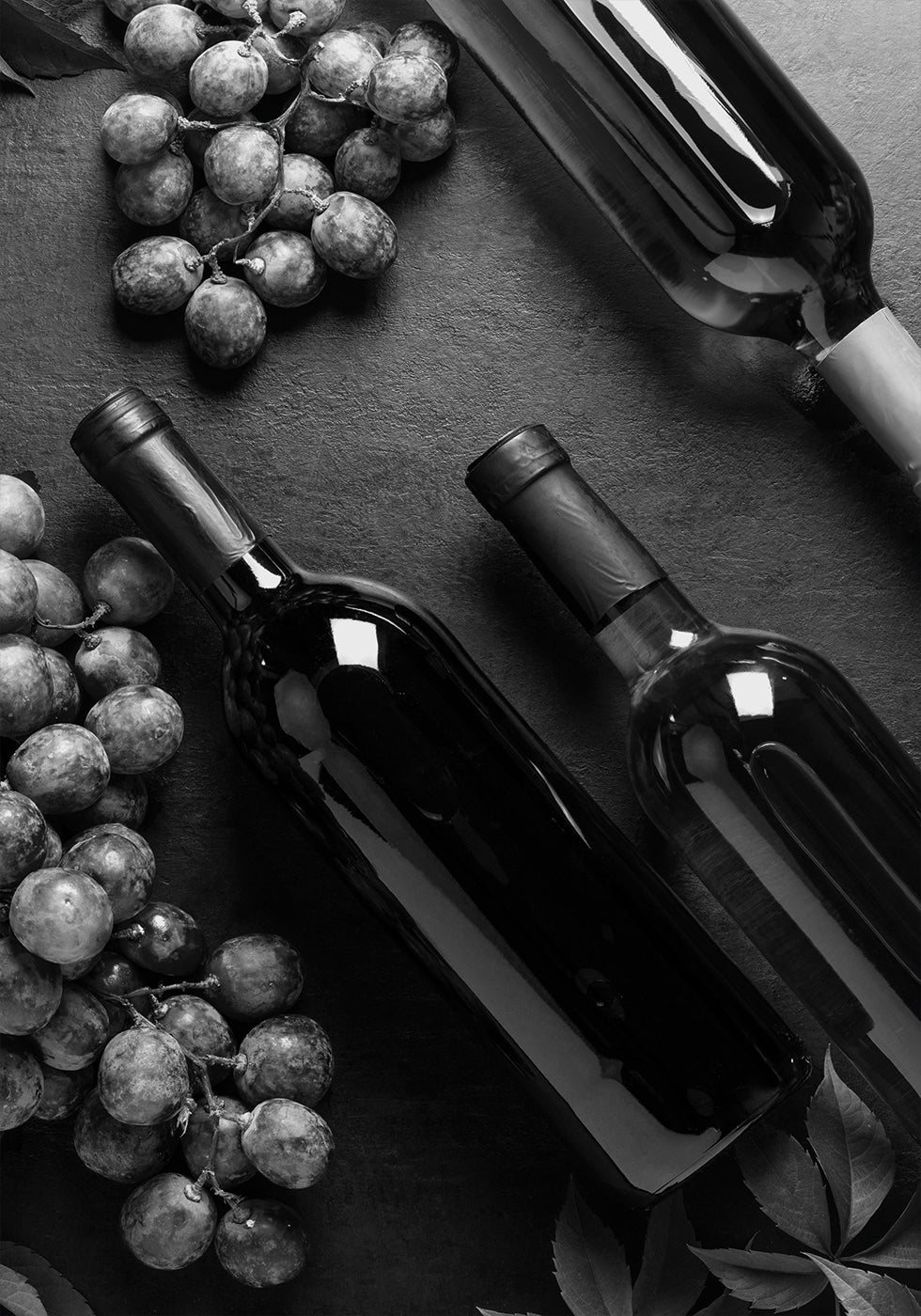 a table topped with bottles of wine and grapes