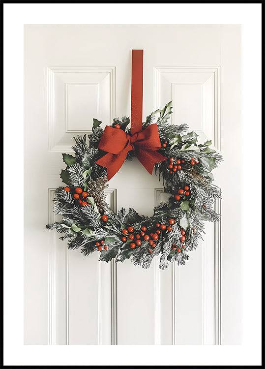 a christmas wreath hanging on a door with a red bow