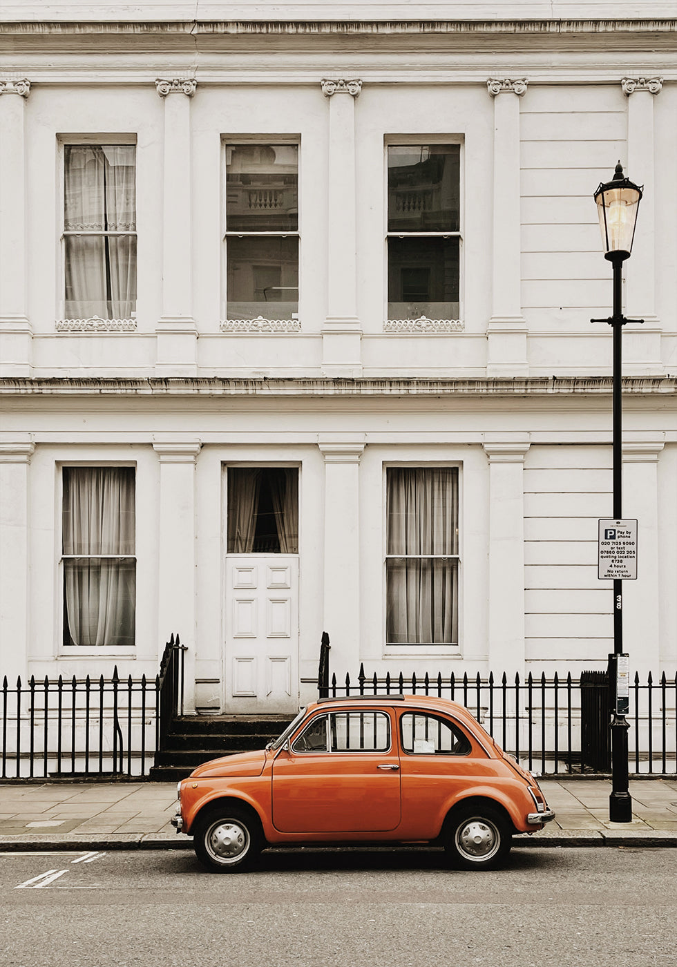 Charming Urban Scene with Orange Car Poster